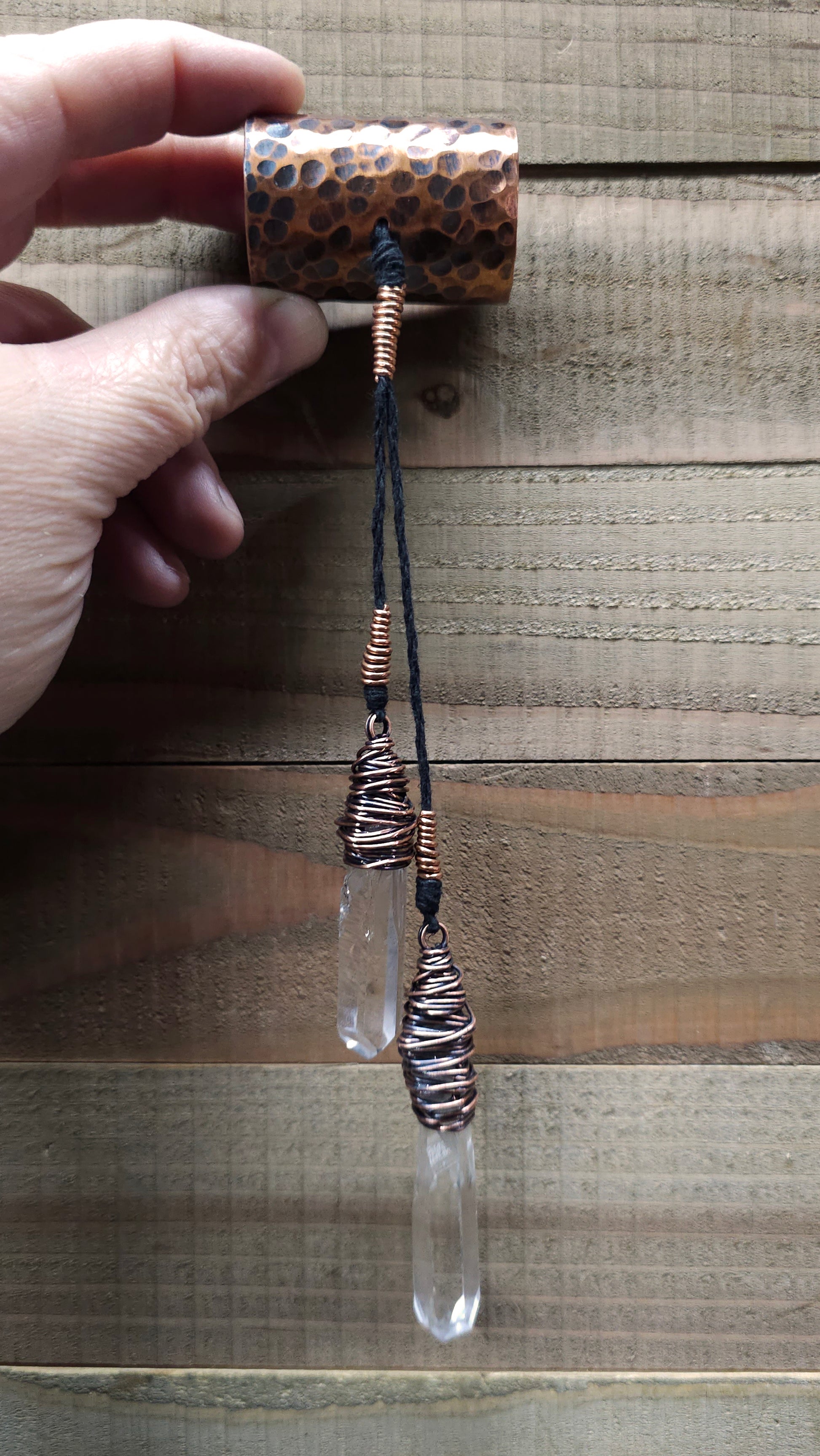 Arkansas Quartz Copper Hair Cuff held by hand against a wood background.