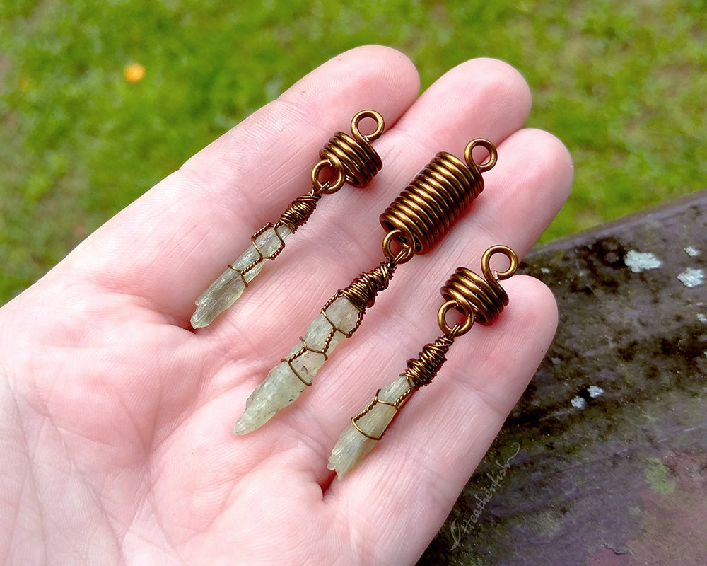 A set of 3 kyanite hair beads held in hand to show scale.