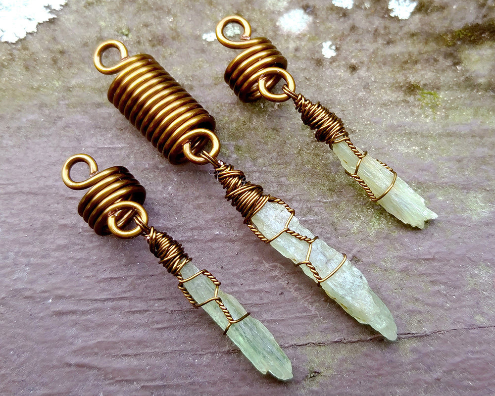 A set of 3 kyanite hair beads on a brown wood background.