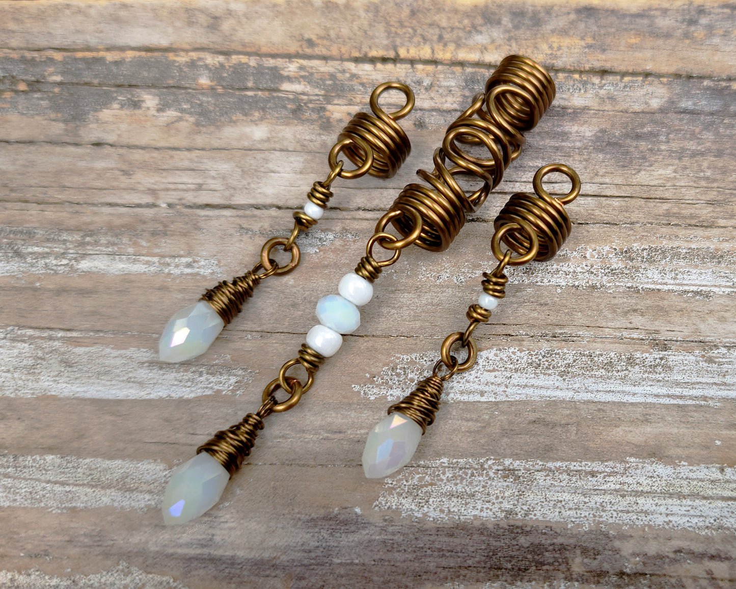 Set of 3 White Glass Loc Beads on wood background.