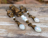 Set of 3 White Glass Loc Beads on wood background.