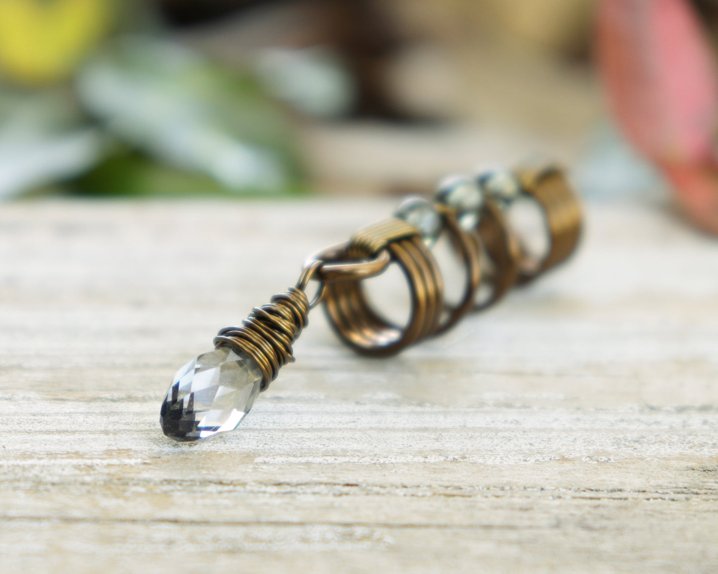 Smoky glass loc bead on a wood background.