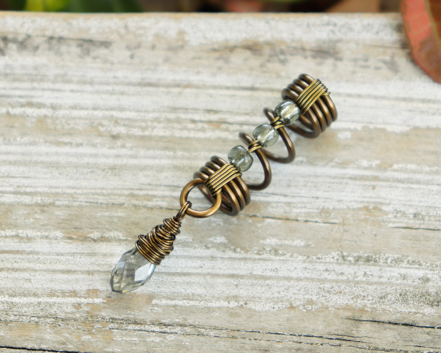 Smoky glass loc bead on a wood background.