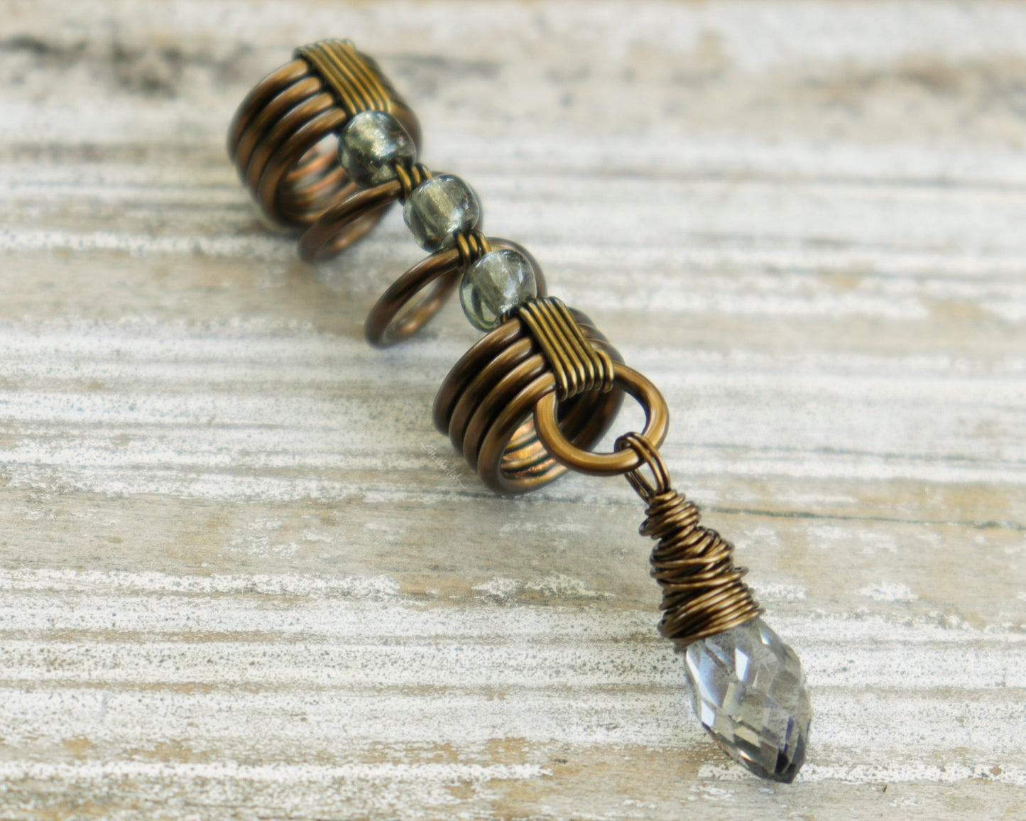 Smoky glass loc bead on a wood background.