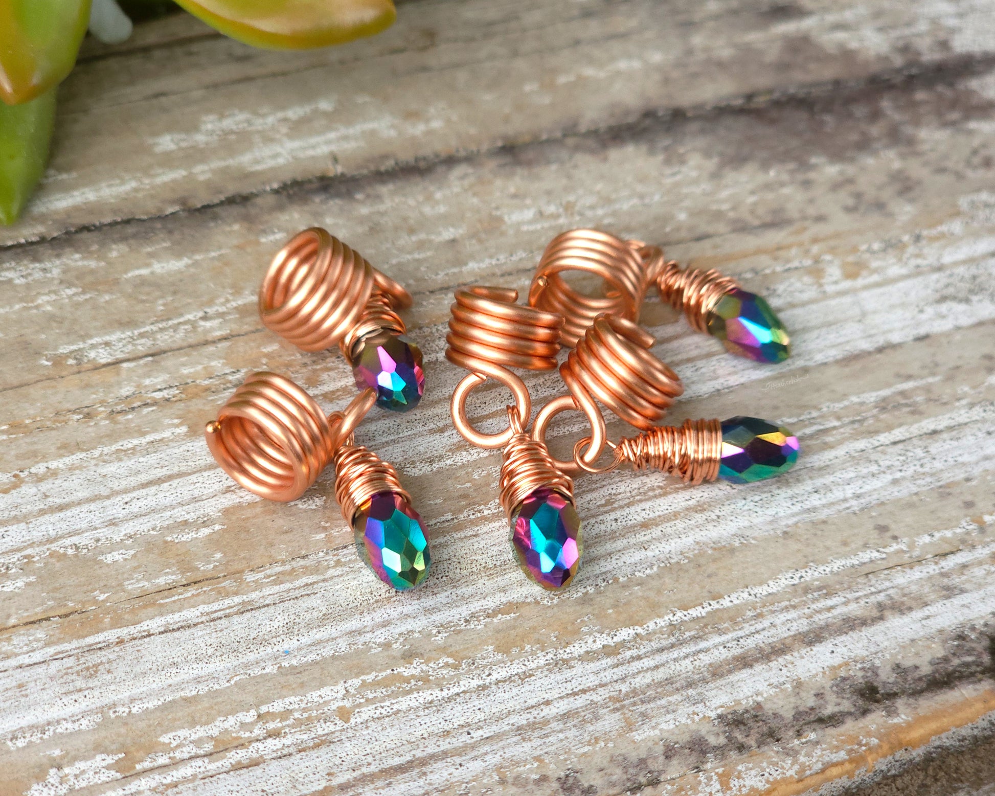 Hair jewelry in a random pile on a wood board.