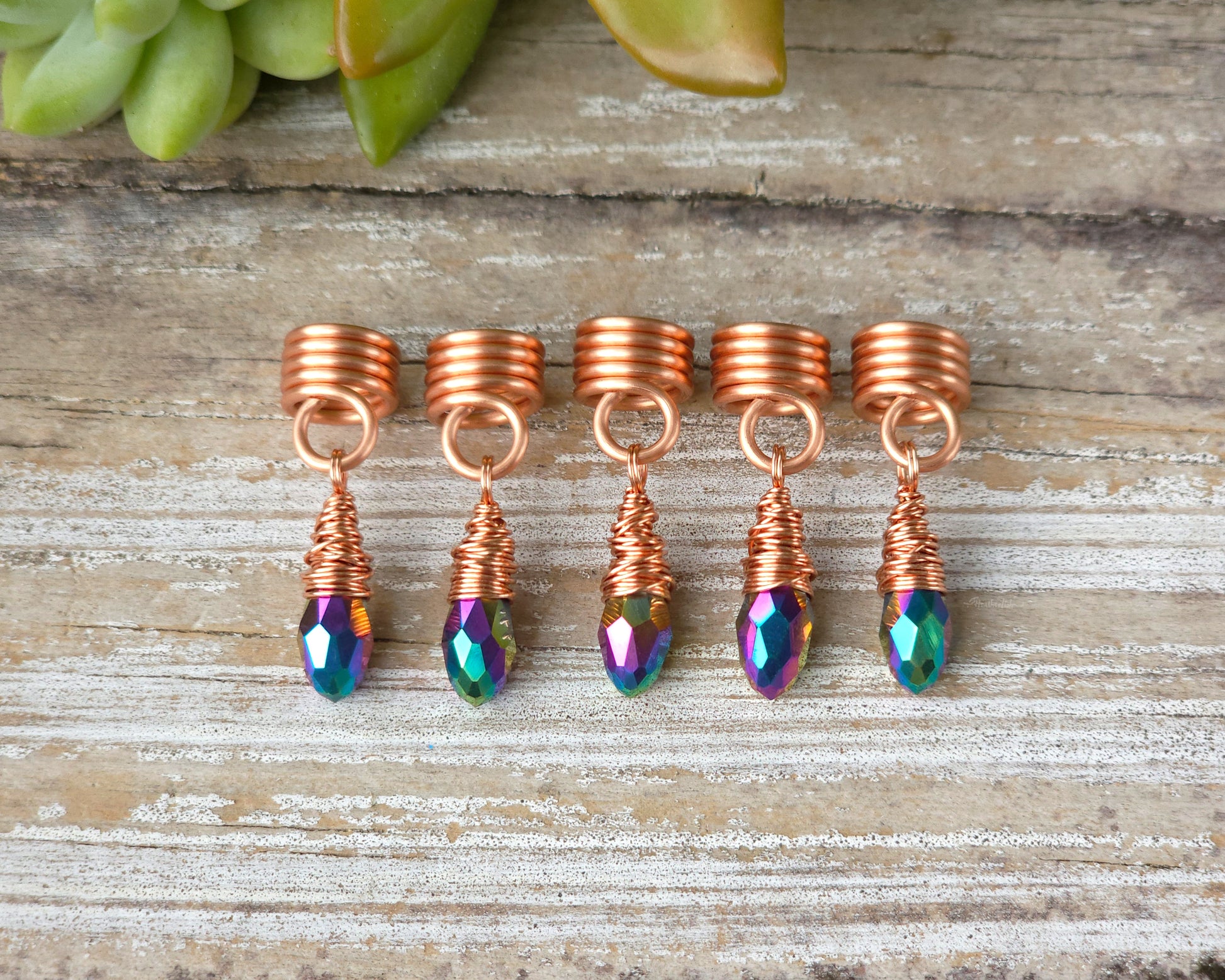 Hair jewelry aligned in a straight row on a wood board.
