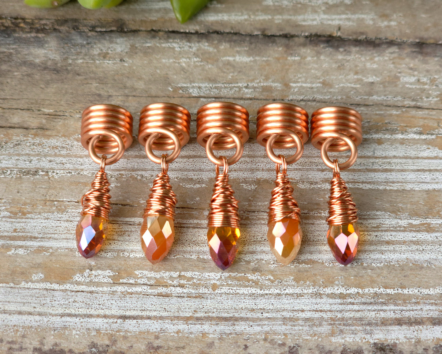 Orange iridescent loc beads, set of 5 in a line on a wood board.