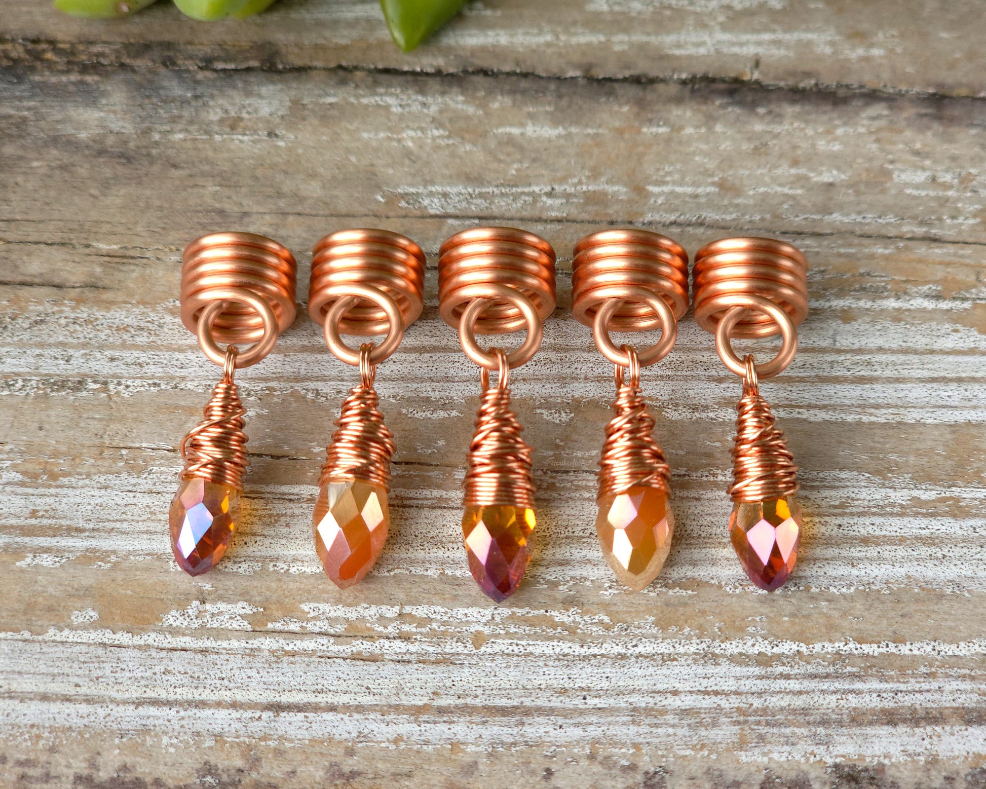 Orange iridescent loc beads, set of 5 in a line on a wood board.