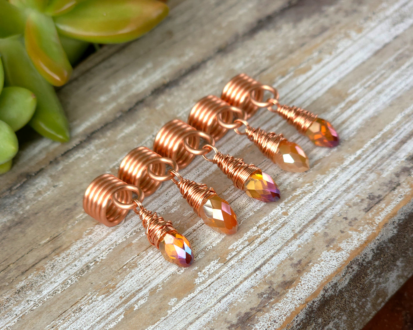 Orange iridescent loc beads, set of 5 on a wood board.