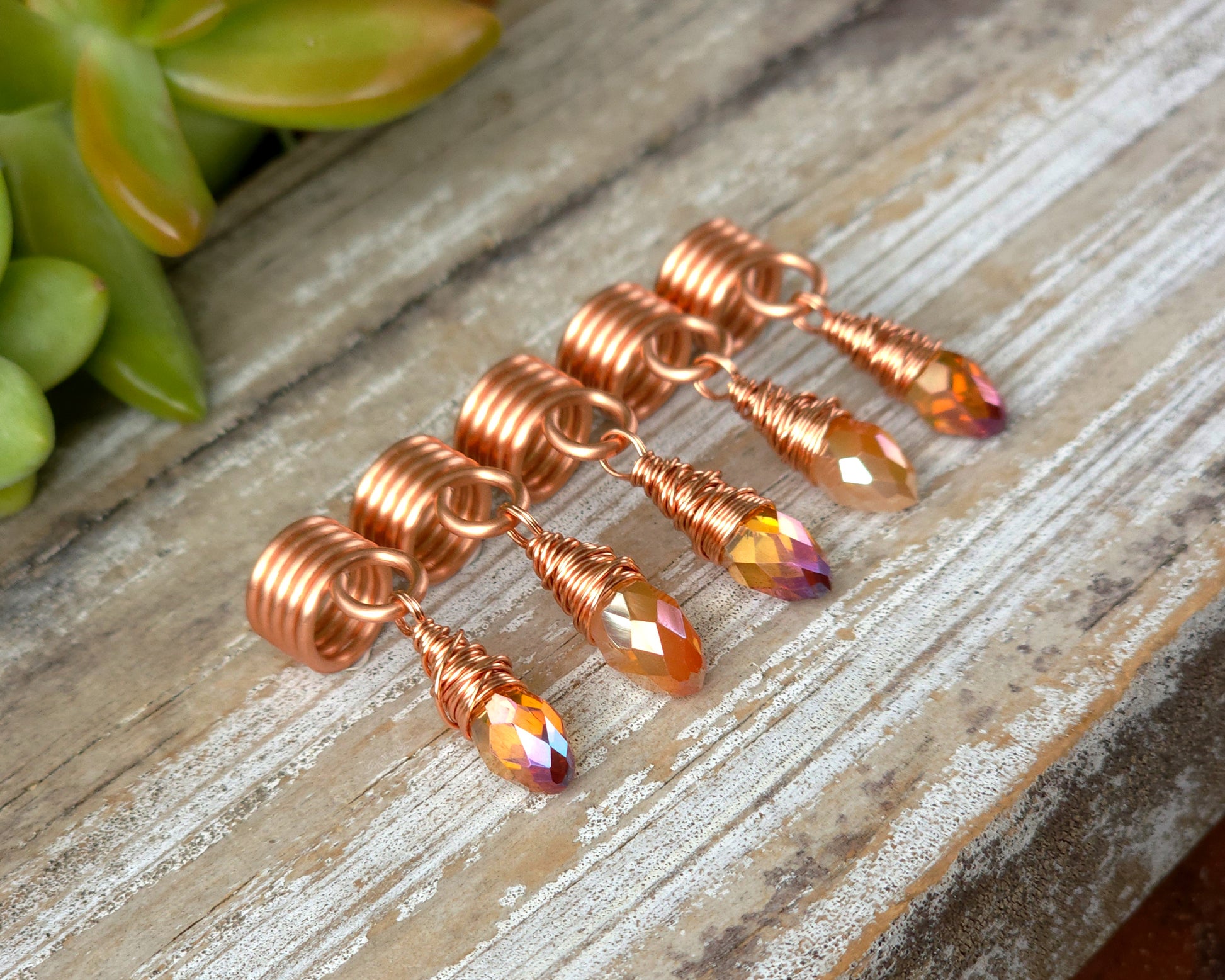 Orange iridescent loc beads, set of 5 on a wood board.