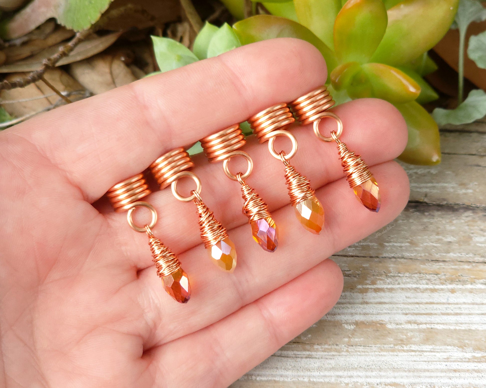 Orange iridescent loc beads, set of 5 held in a hand to show scale.