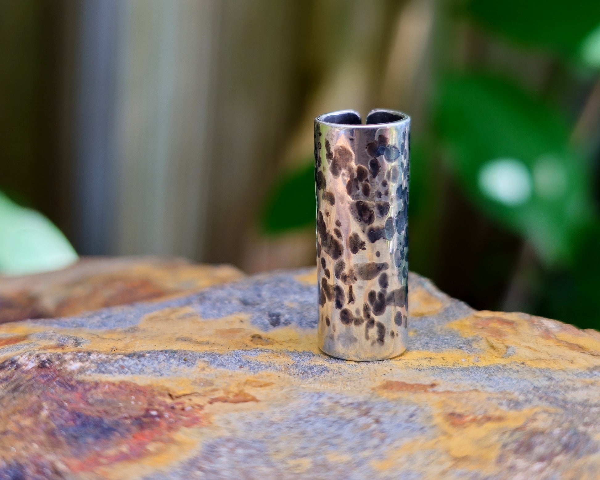 Sterling silver dread bead on a rock.
