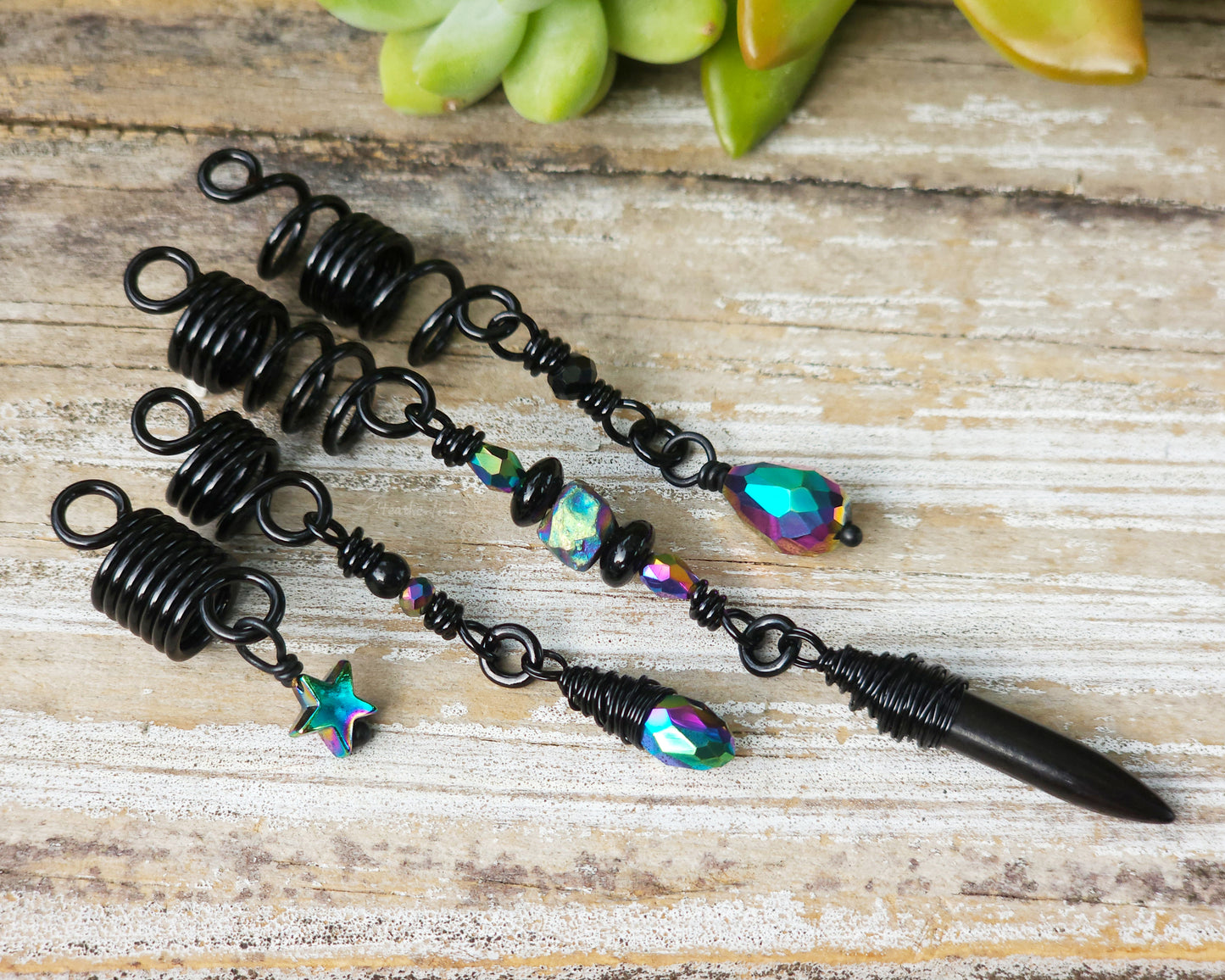 Black rainbow set of 4 dread beads on a wood board.