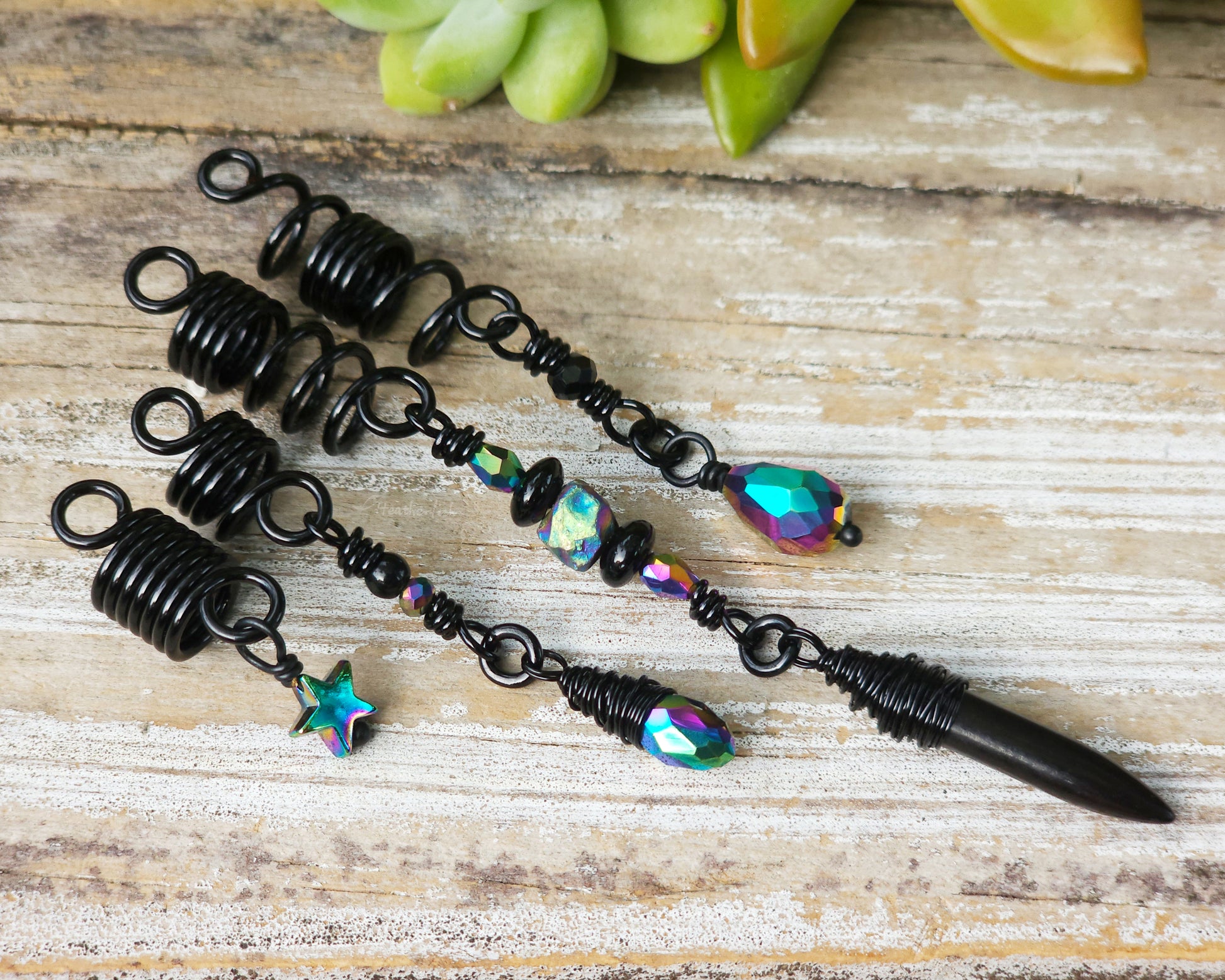 Black rainbow set of 4 dread beads on a wood board.
