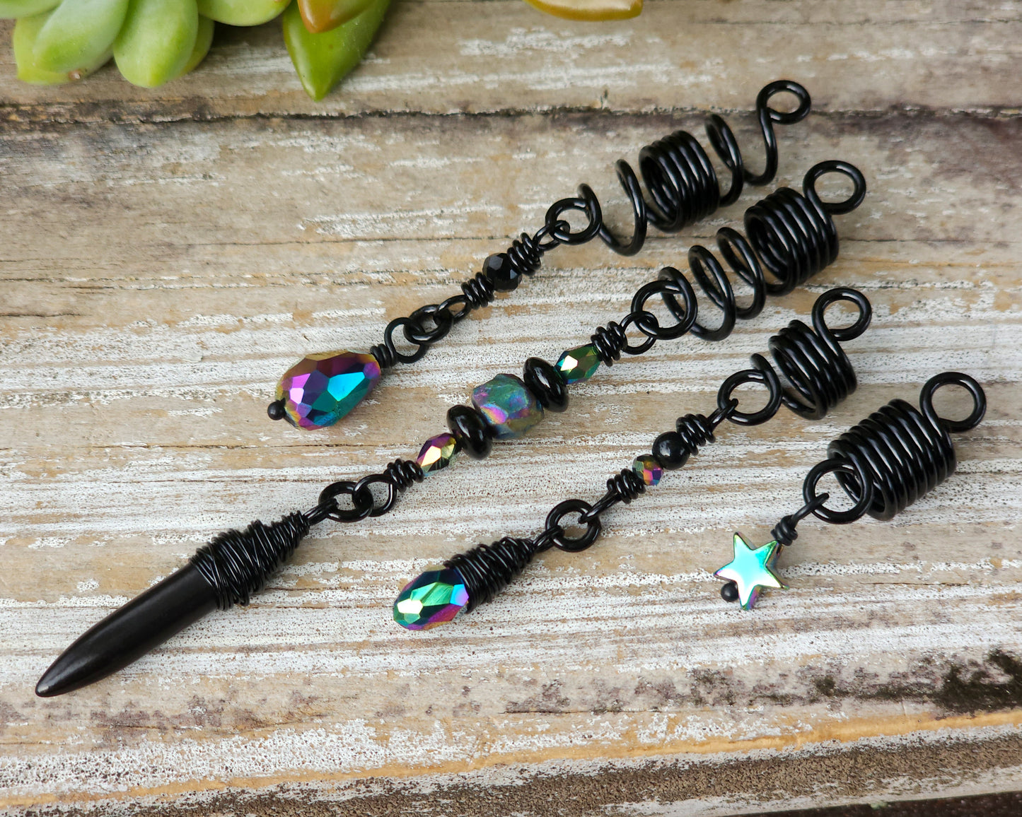Black rainbow set of 4 dread beads on a wood board.