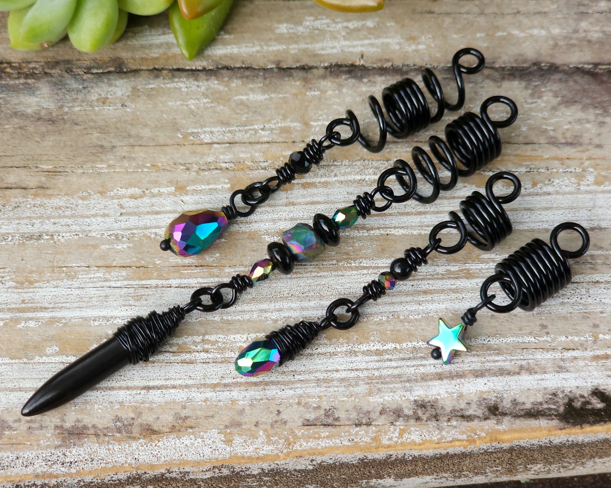 Black rainbow set of 4 dread beads on a wood board.