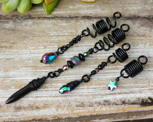 Black rainbow set of 4 dread beads on a wood board.