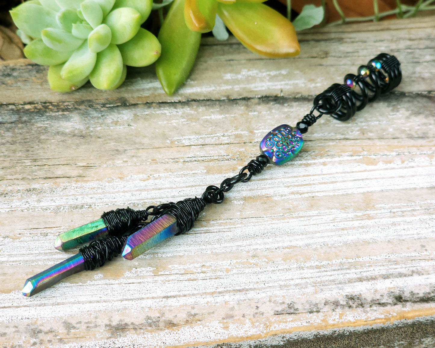 Triple rainbow titanium quartz dreadlock bead on a wood board.
