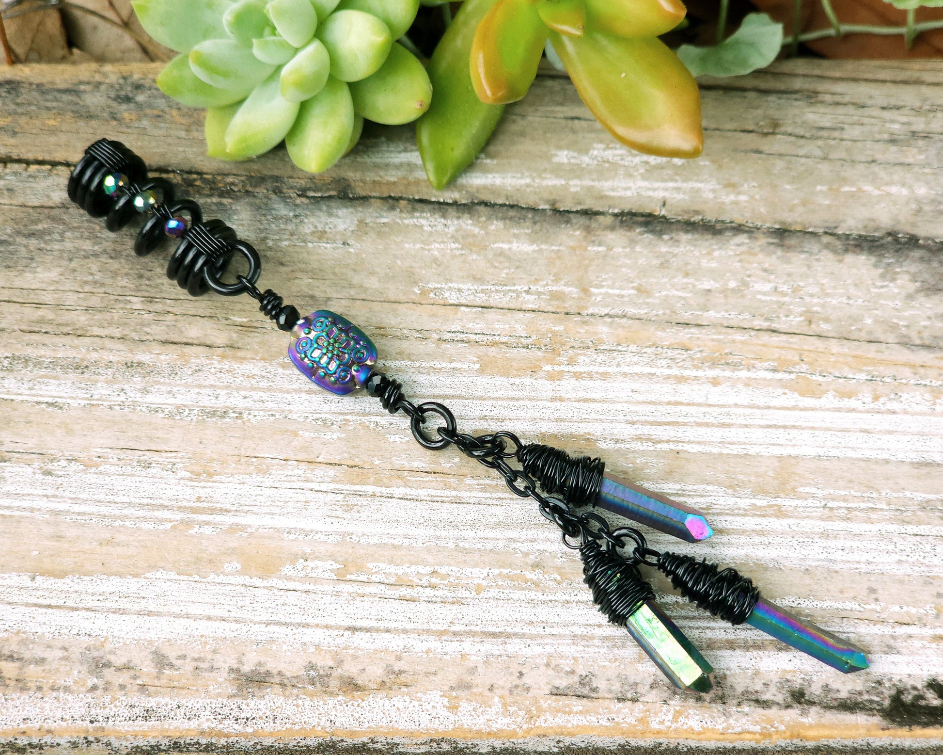 Triple rainbow titanium quartz dreadlock bead on a wood board.