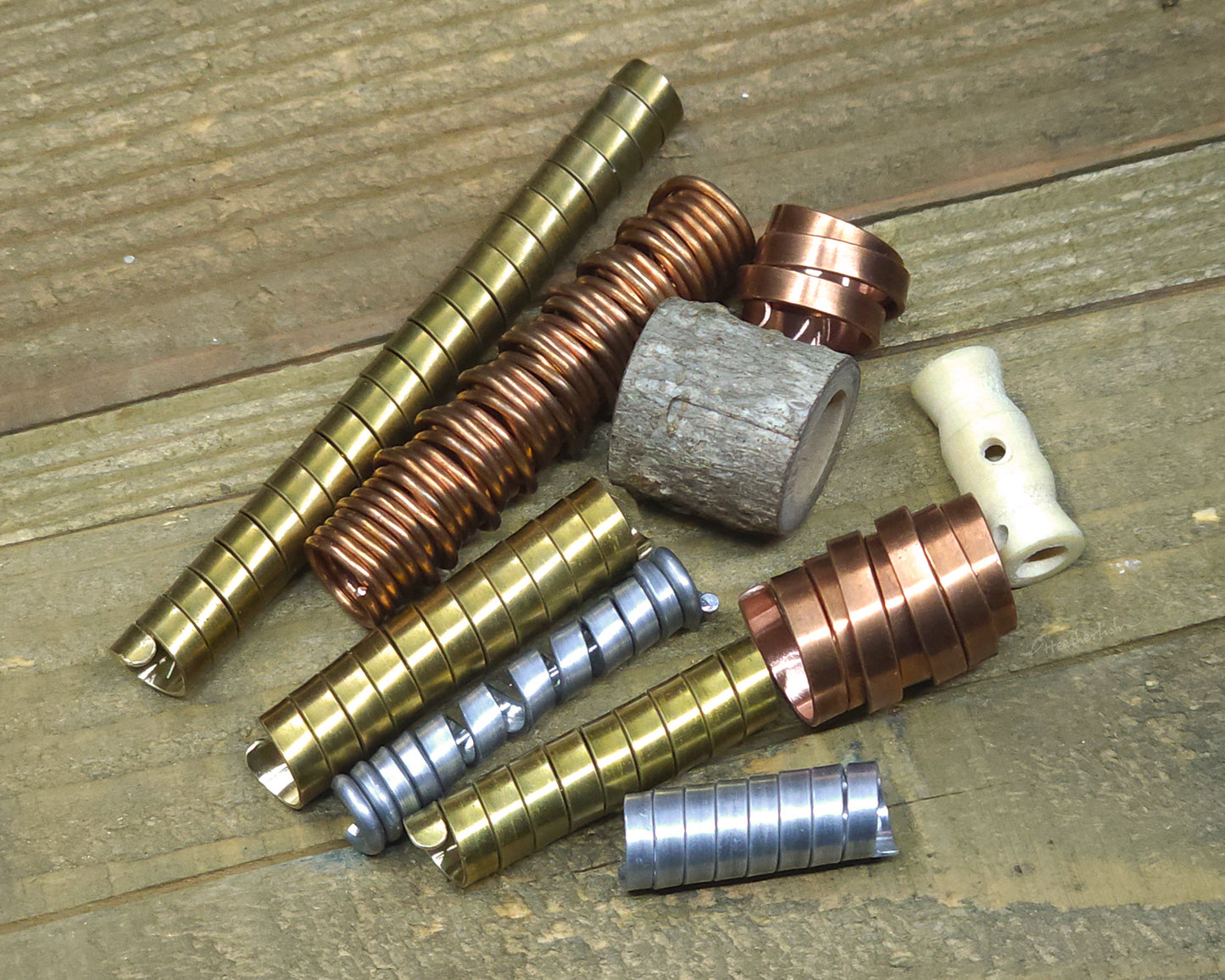 Collection of various dreadlock beads against a wood surface.