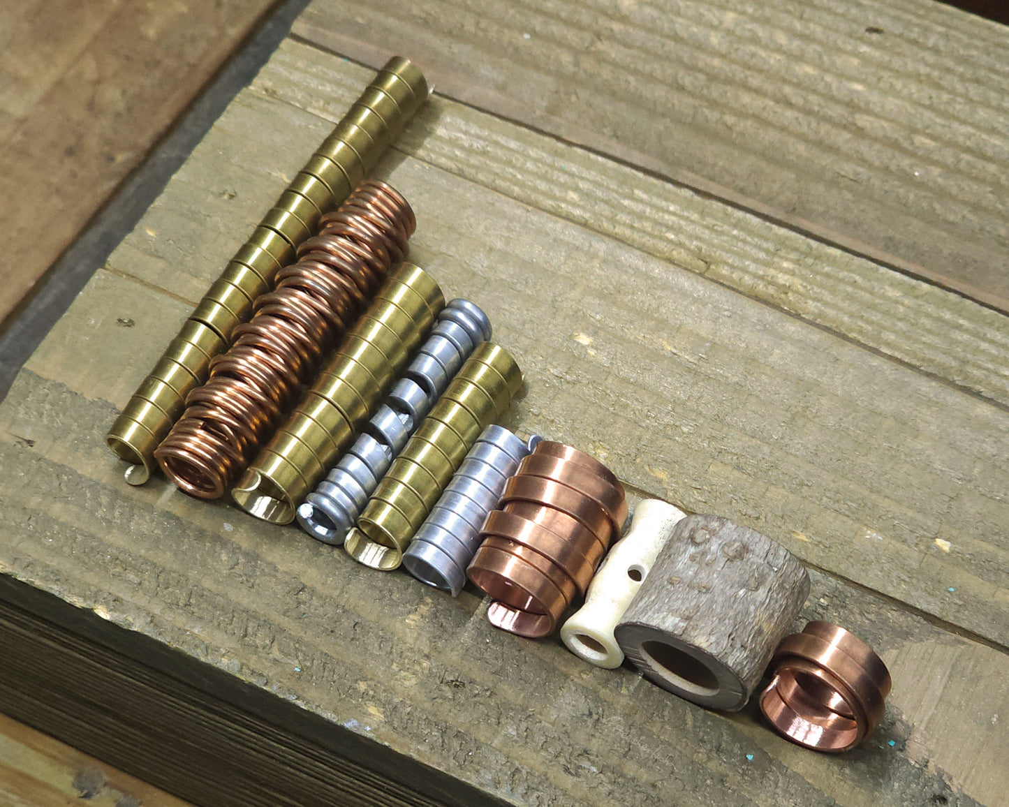 Collection of various dreadlock beads against a wood surface.