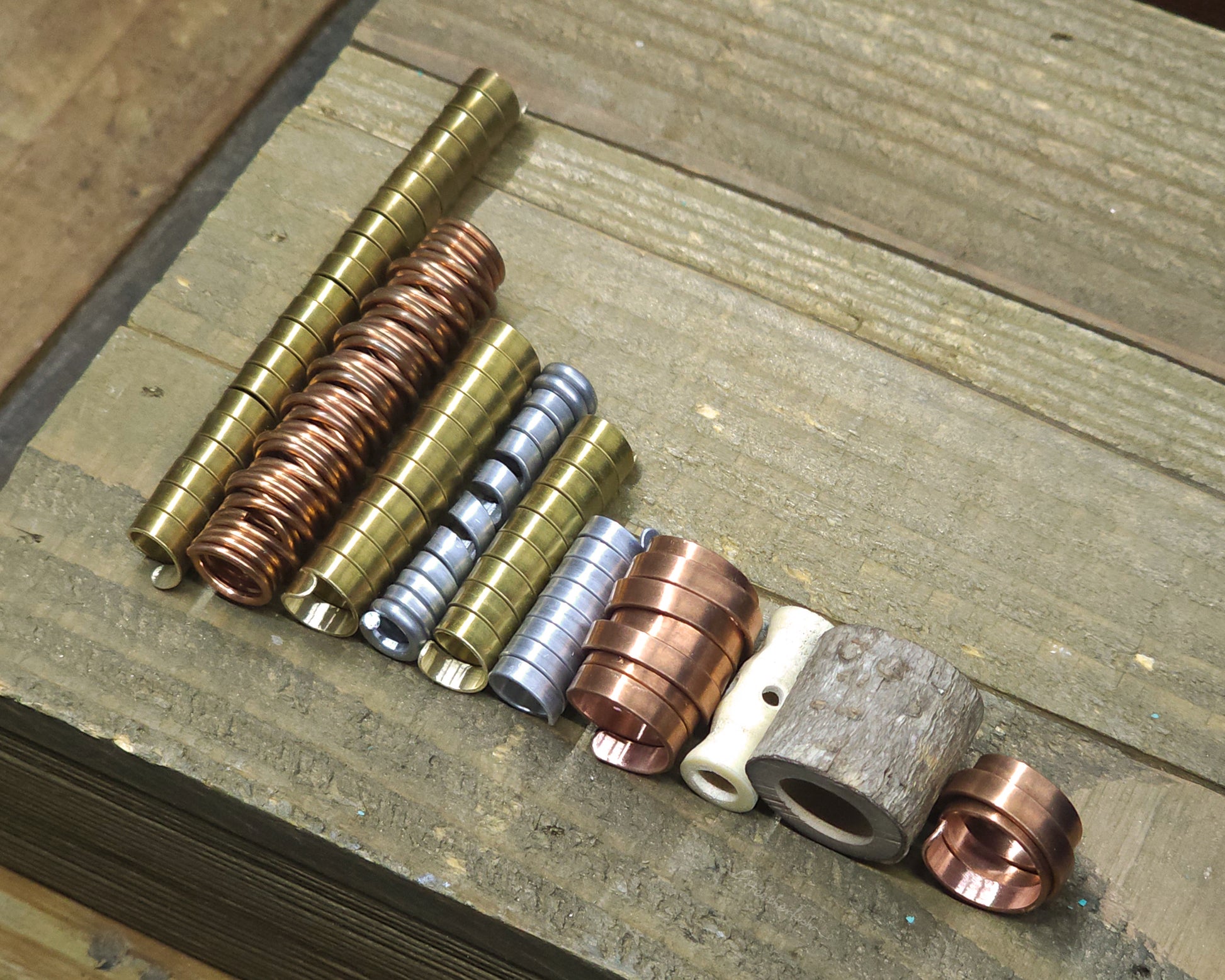 Collection of various dreadlock beads against a wood surface.