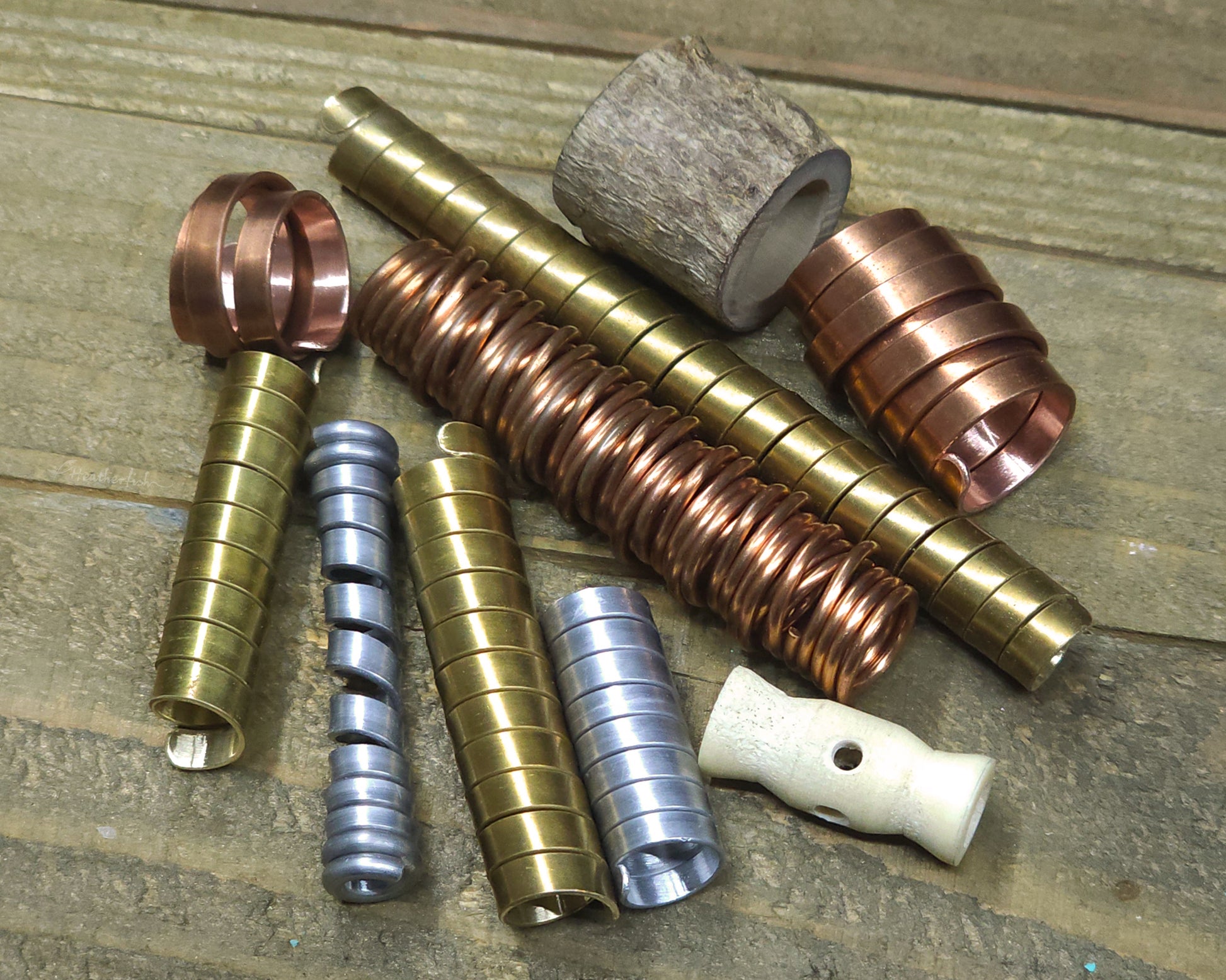 Collection of various dreadlock beads against a wood surface.