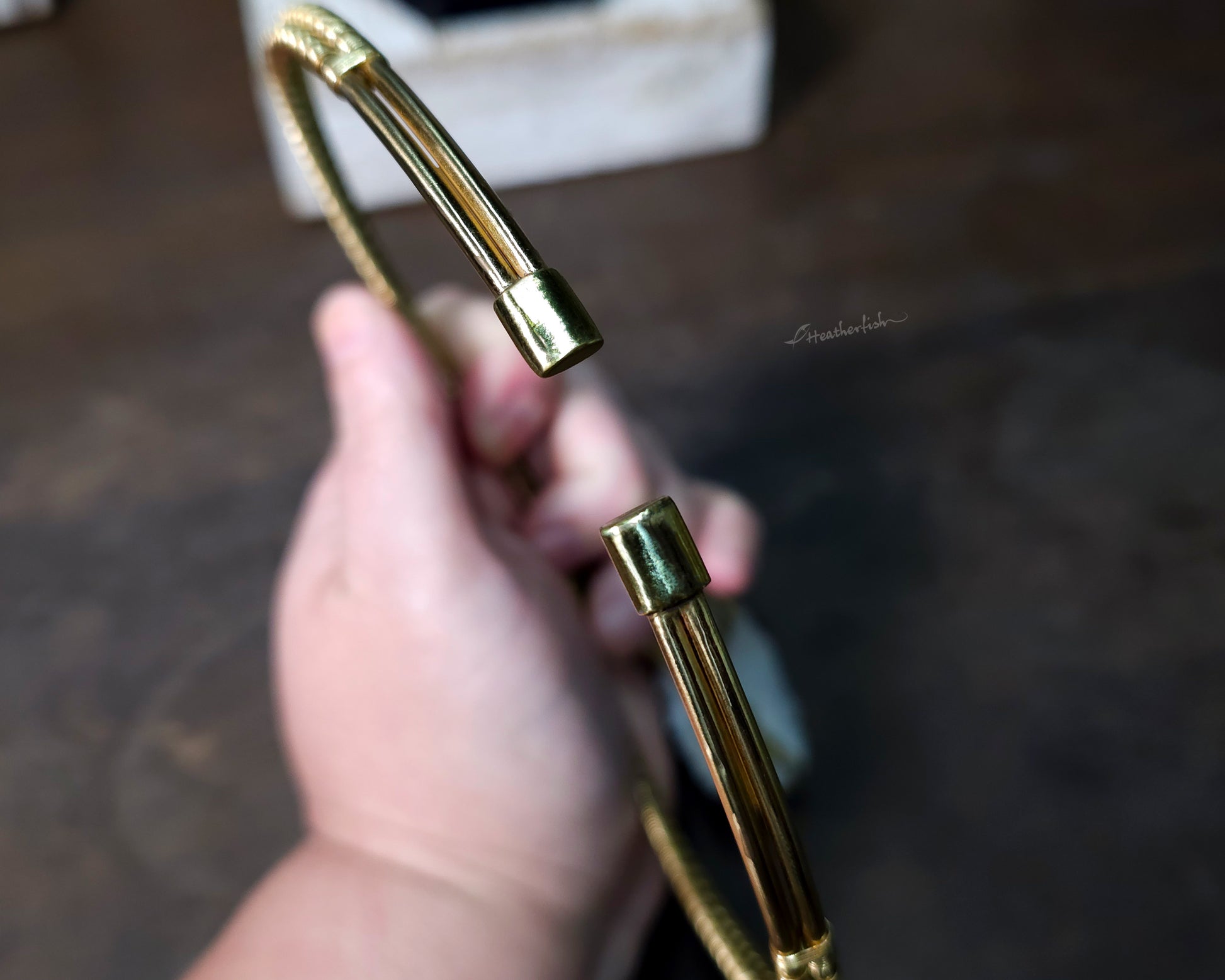 Close up of yellow brass torque necklace end caps.