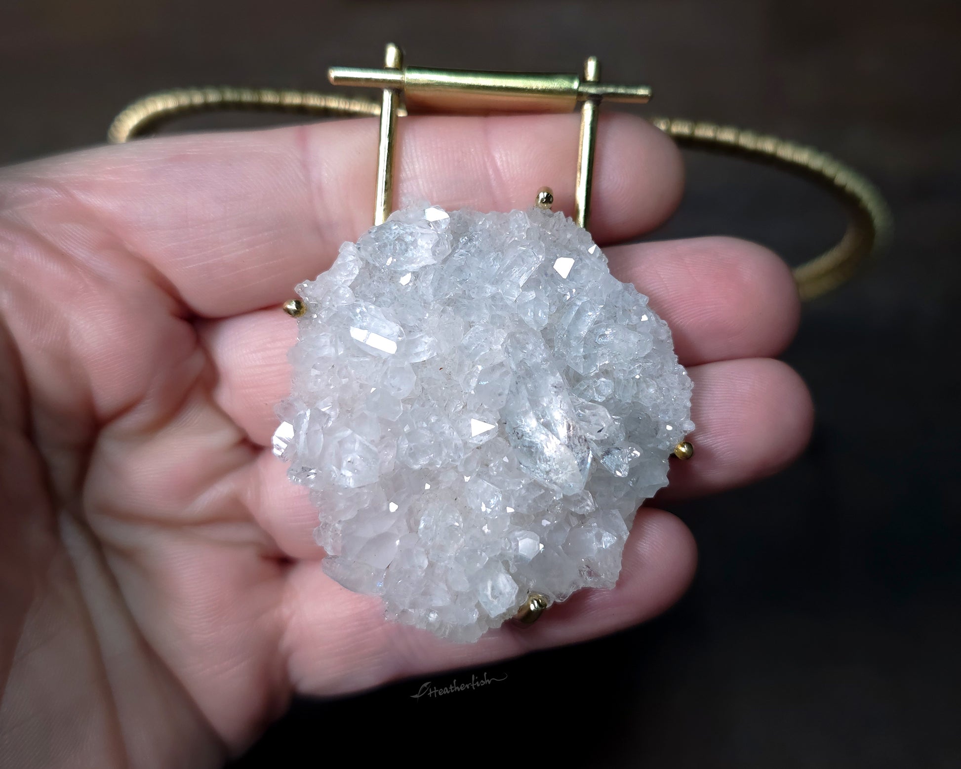 Close up of Arkansas Quartz Cluster pendant held in hand.