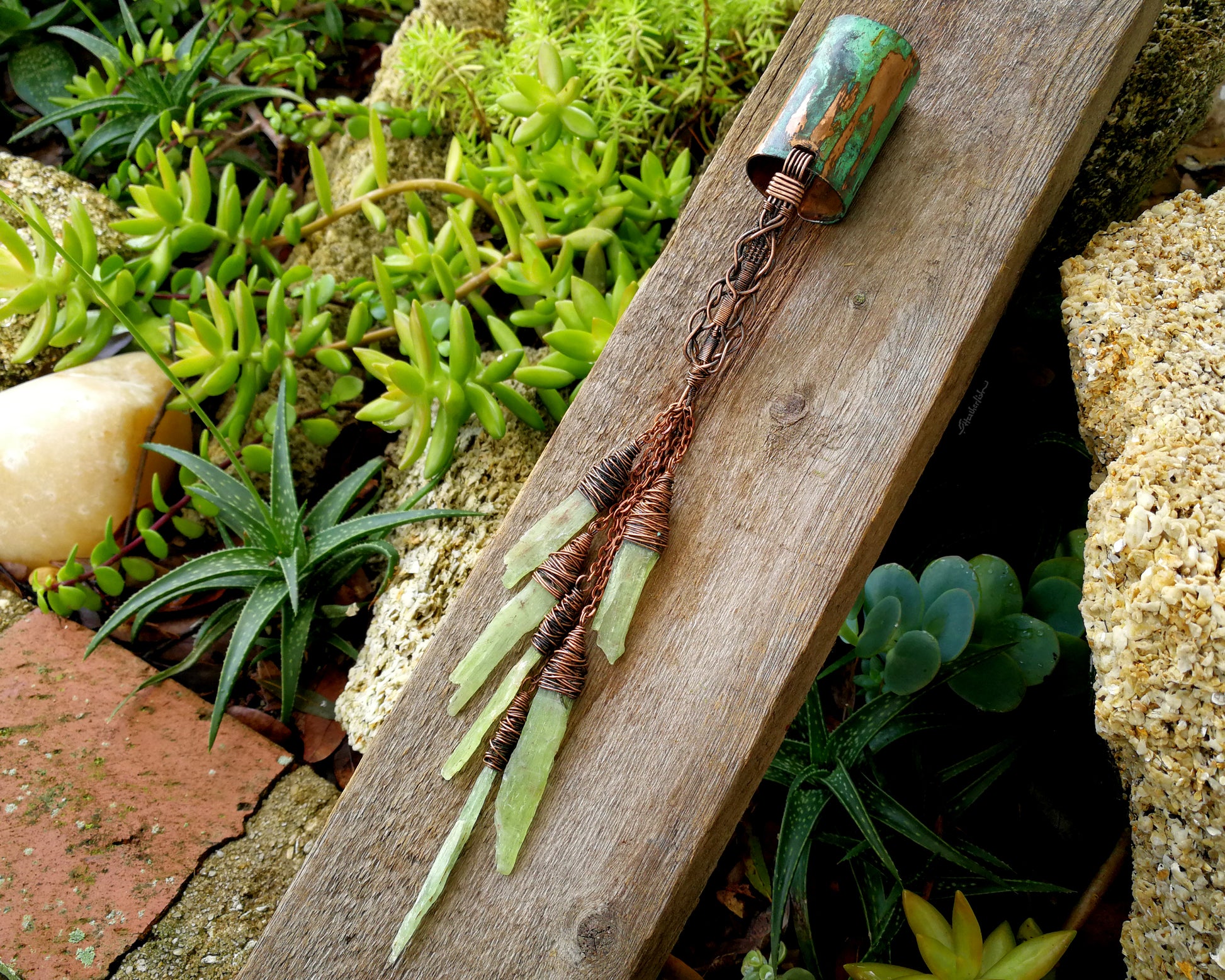 A large kyanite hair cuff on a wood board.