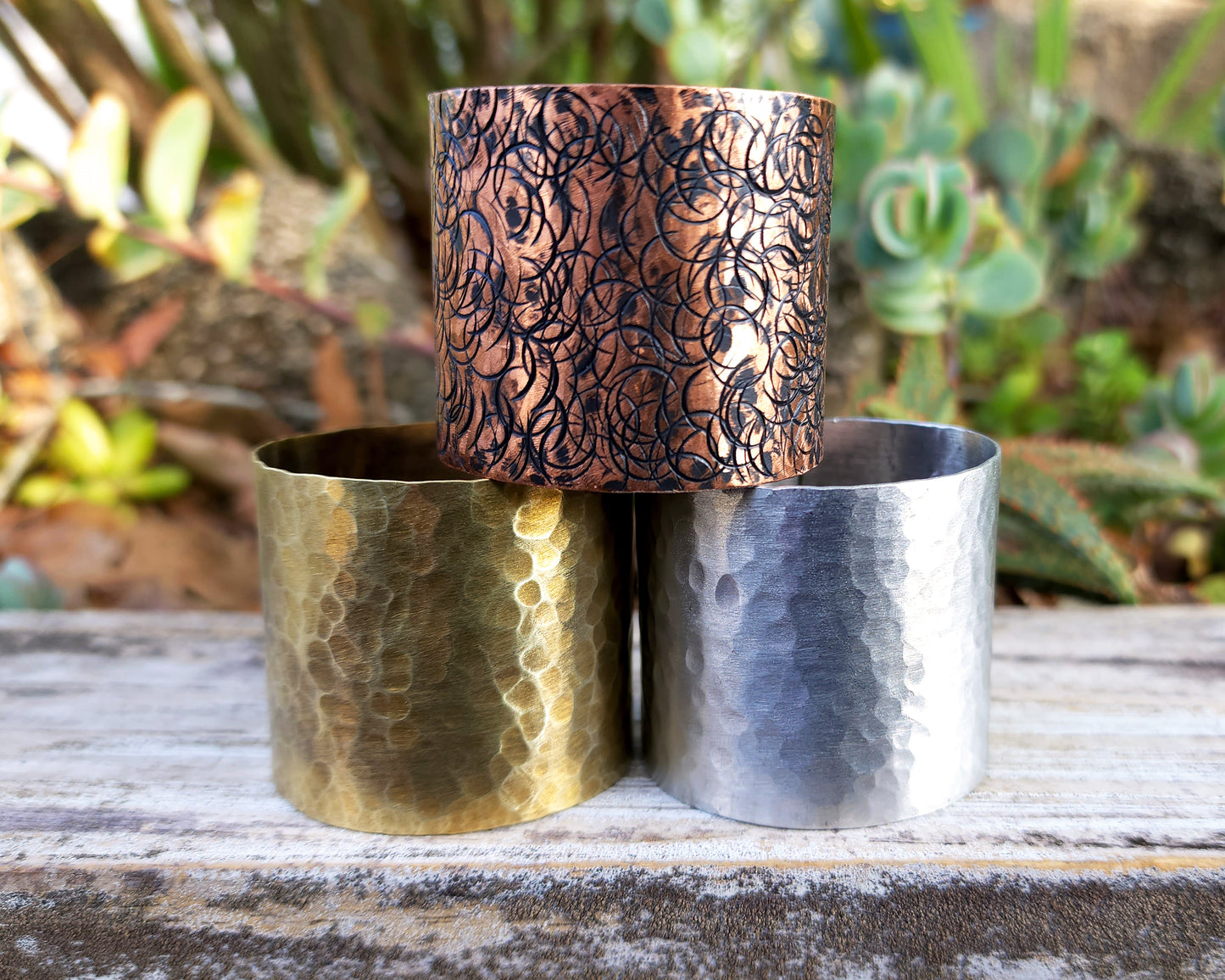 Large hair cuffs stacked and displayed on wood background.