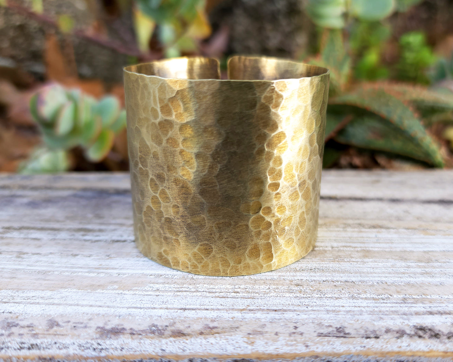 Brass hair cuff on wood background.
