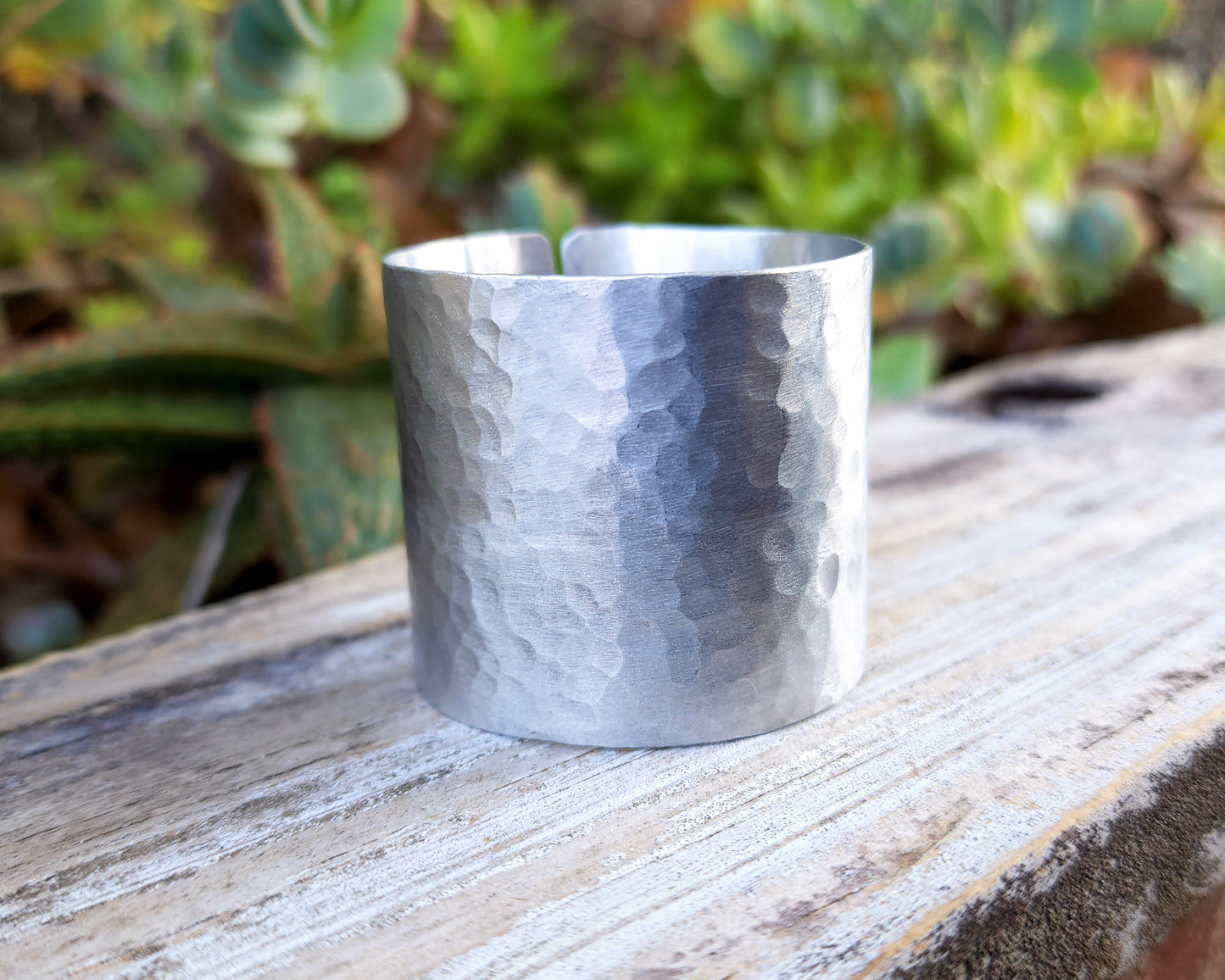 Aluminum hair cuff on wood background.