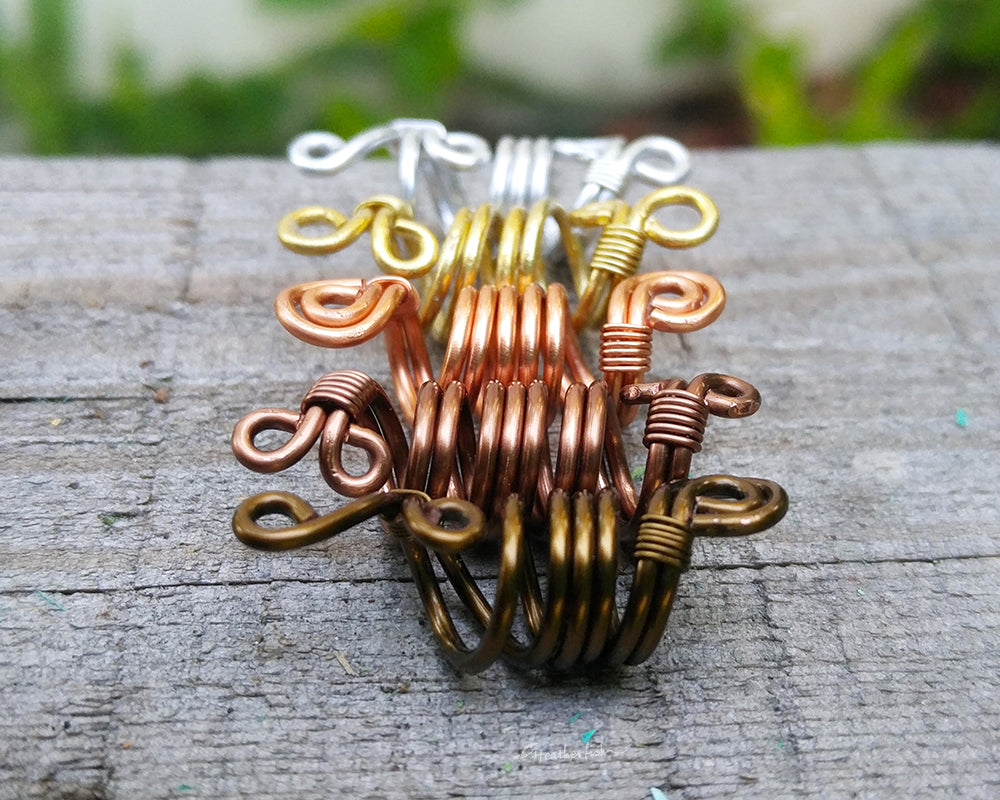 Side view of a set of 5 ombre dread beads on painted wood surface.