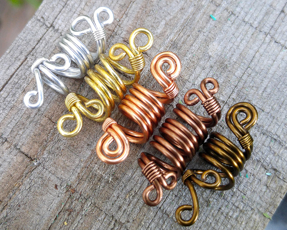 Top view of a set of 5 ombre dread beads on painted wood surface.