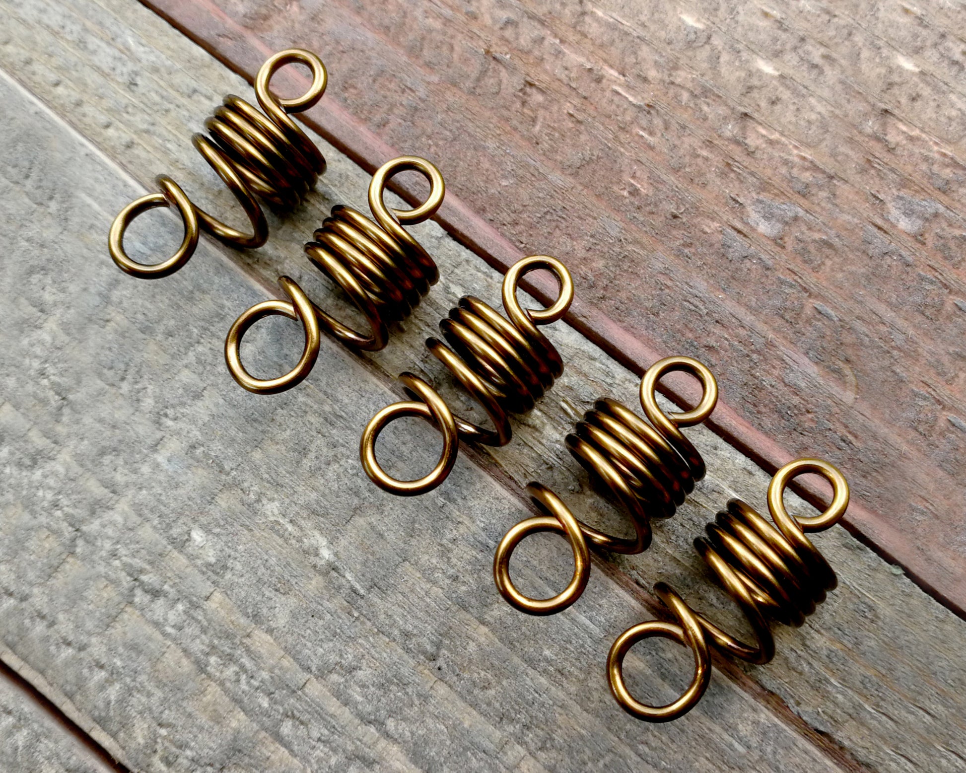 Set of 5 filigree beads on wood background.