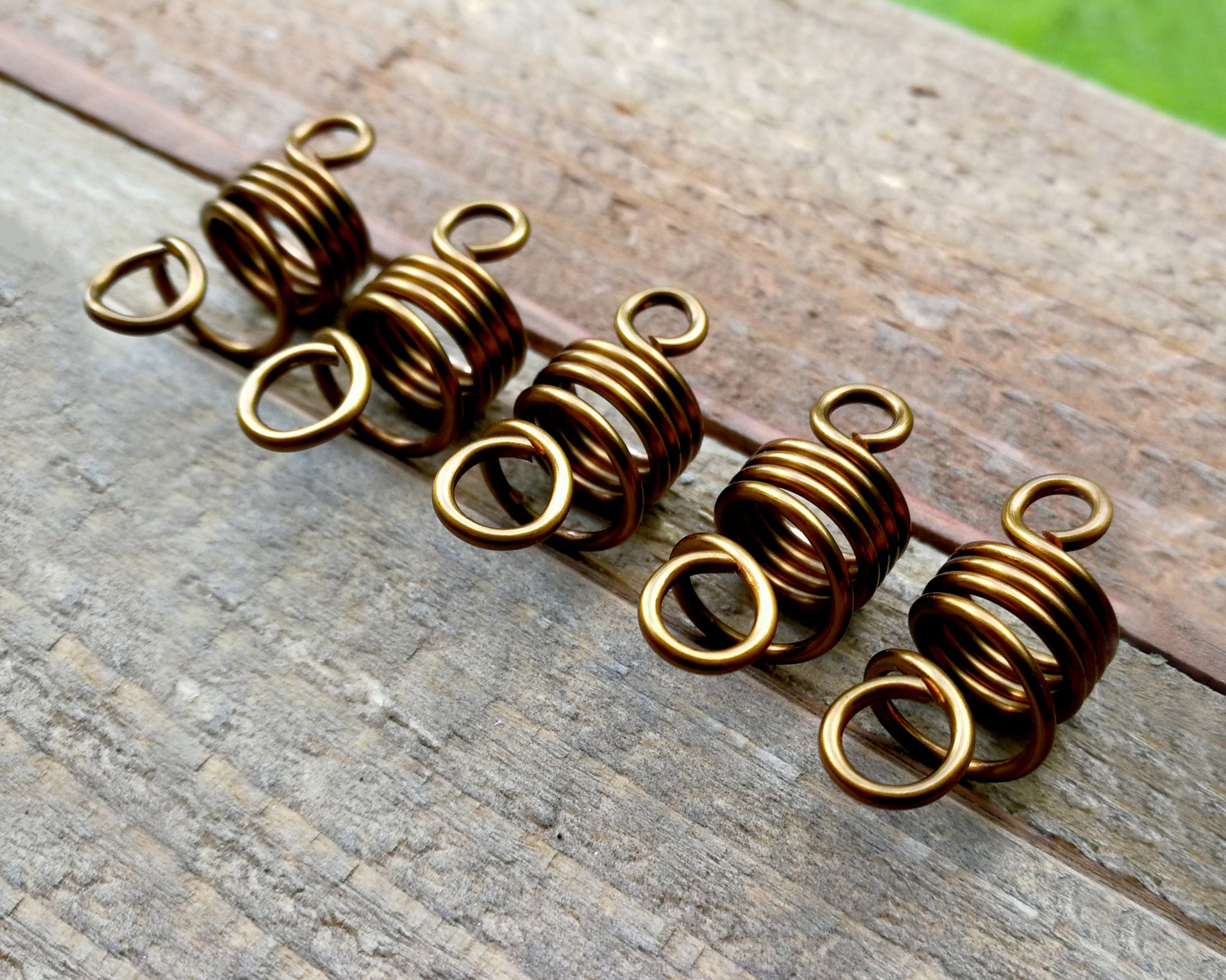 Set of 5 filigree beads on wood background.