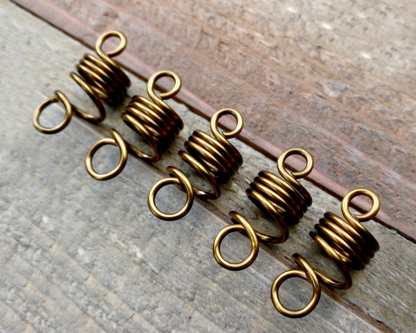 Set of 5 filigree beads on wood background.