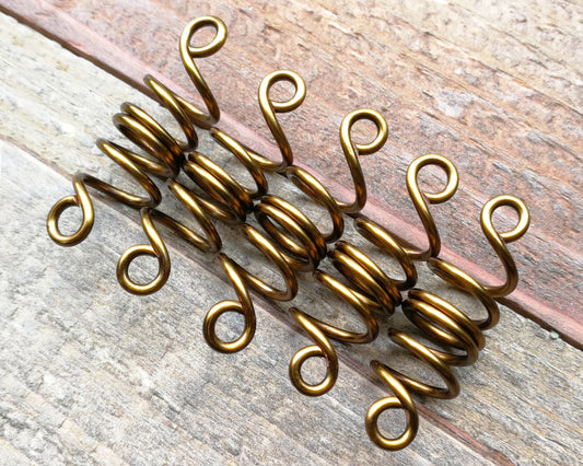 Set of 5 filigree beads on wood background.