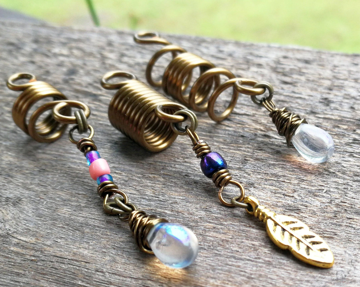 Set of 3 fall color dread beads on wood background.