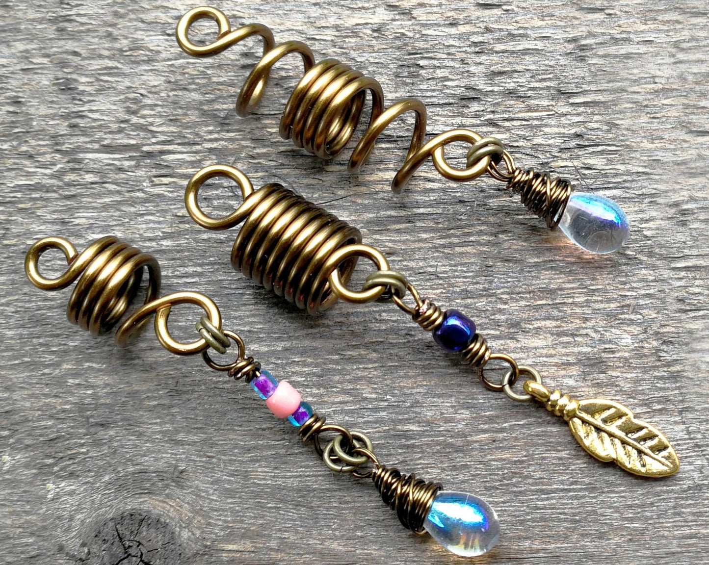 Set of 3 fall color dread beads on wood background.