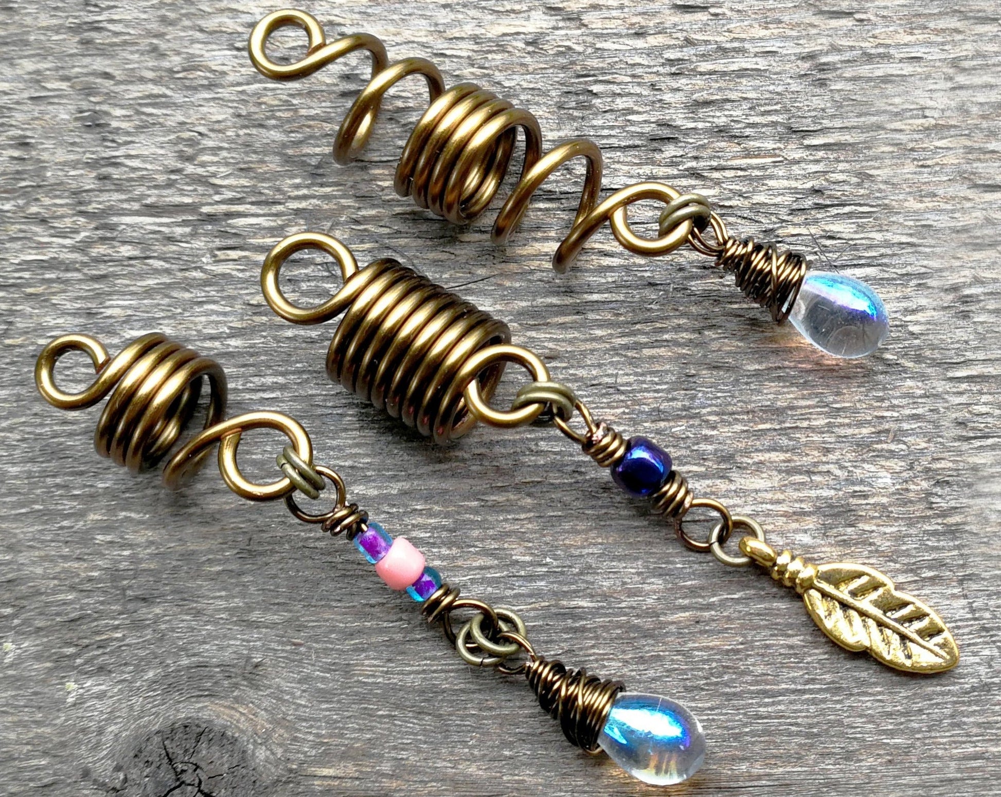 Set of 3 fall color dread beads on wood background.