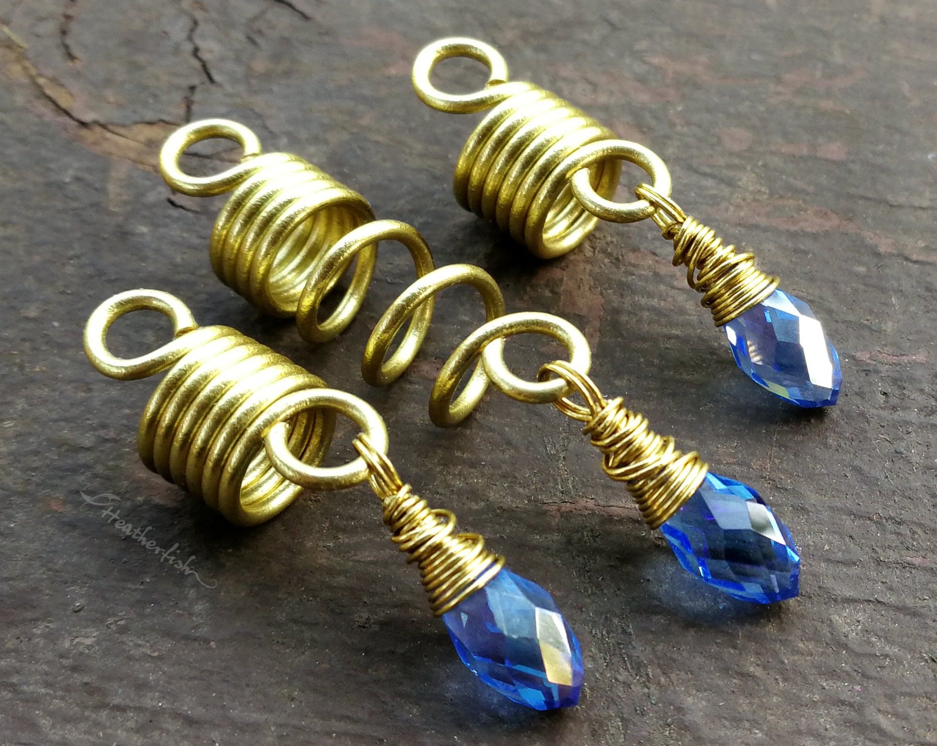 Set of 3 dread beads with periwinkle glass accents on a painted wood background.