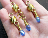 Set of 3 dread beads with periwinkle glass accents placed in hand to show scale.