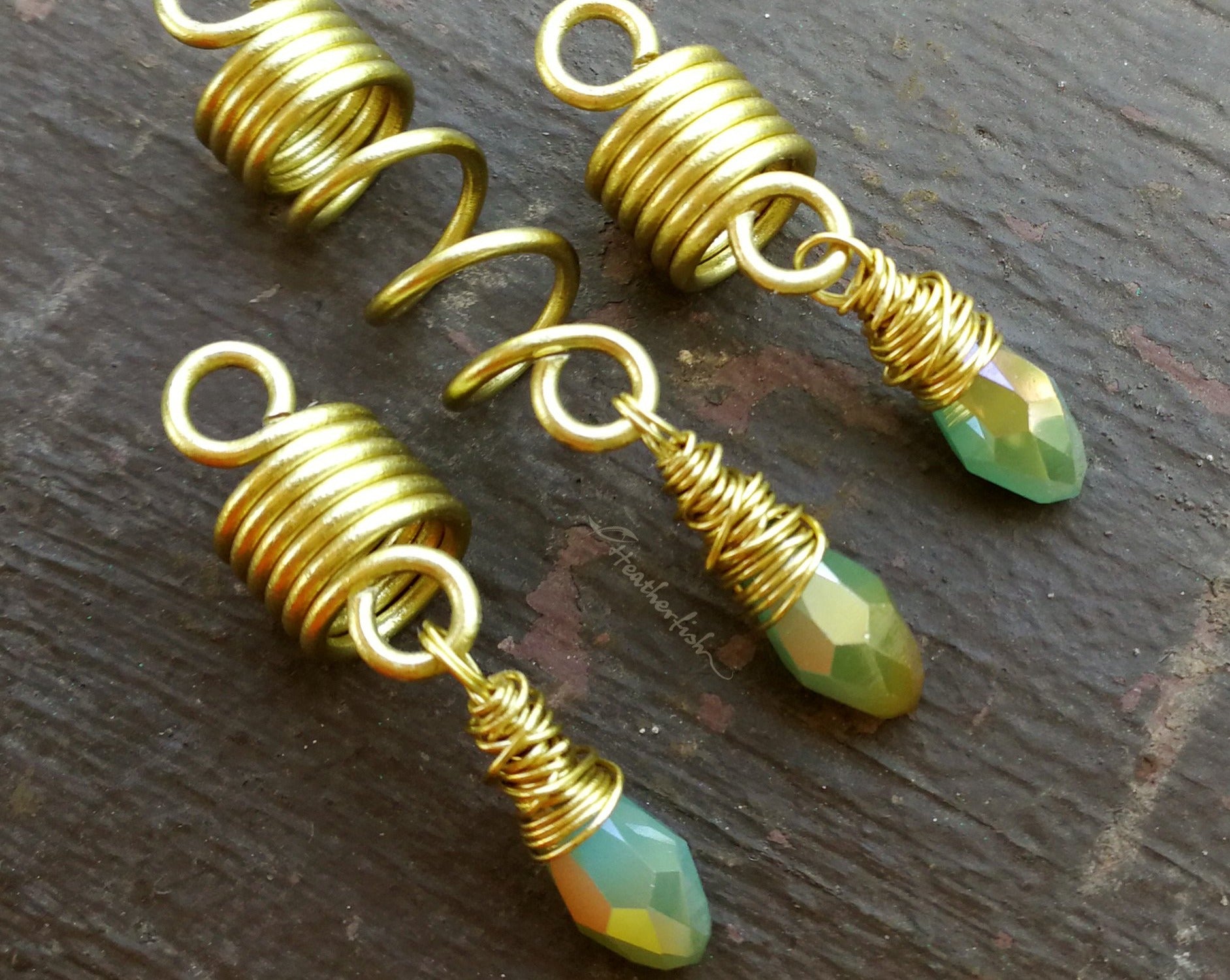 Light Blue, Gold Loc Beads, Set of 3 displayed on painted wood background.