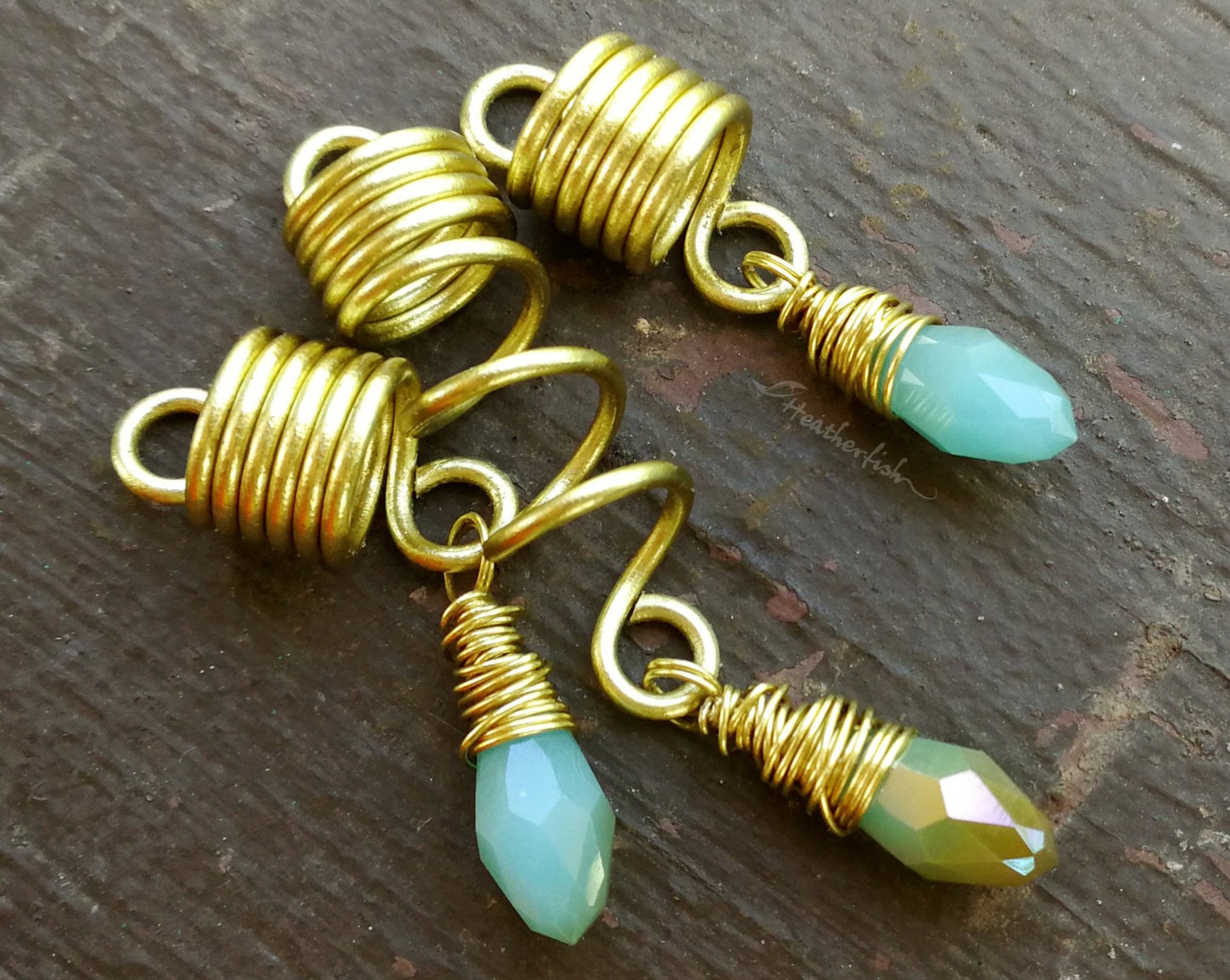 Light Blue, Gold Loc Beads, Set of 3 displayed on painted wood background.