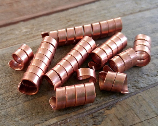 A top view of Varied length Copper Dread Beads Set of 10.