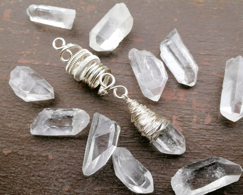 Woven Silver Dread Bead featuring and arkansas quartz crystal on a painted wood background.