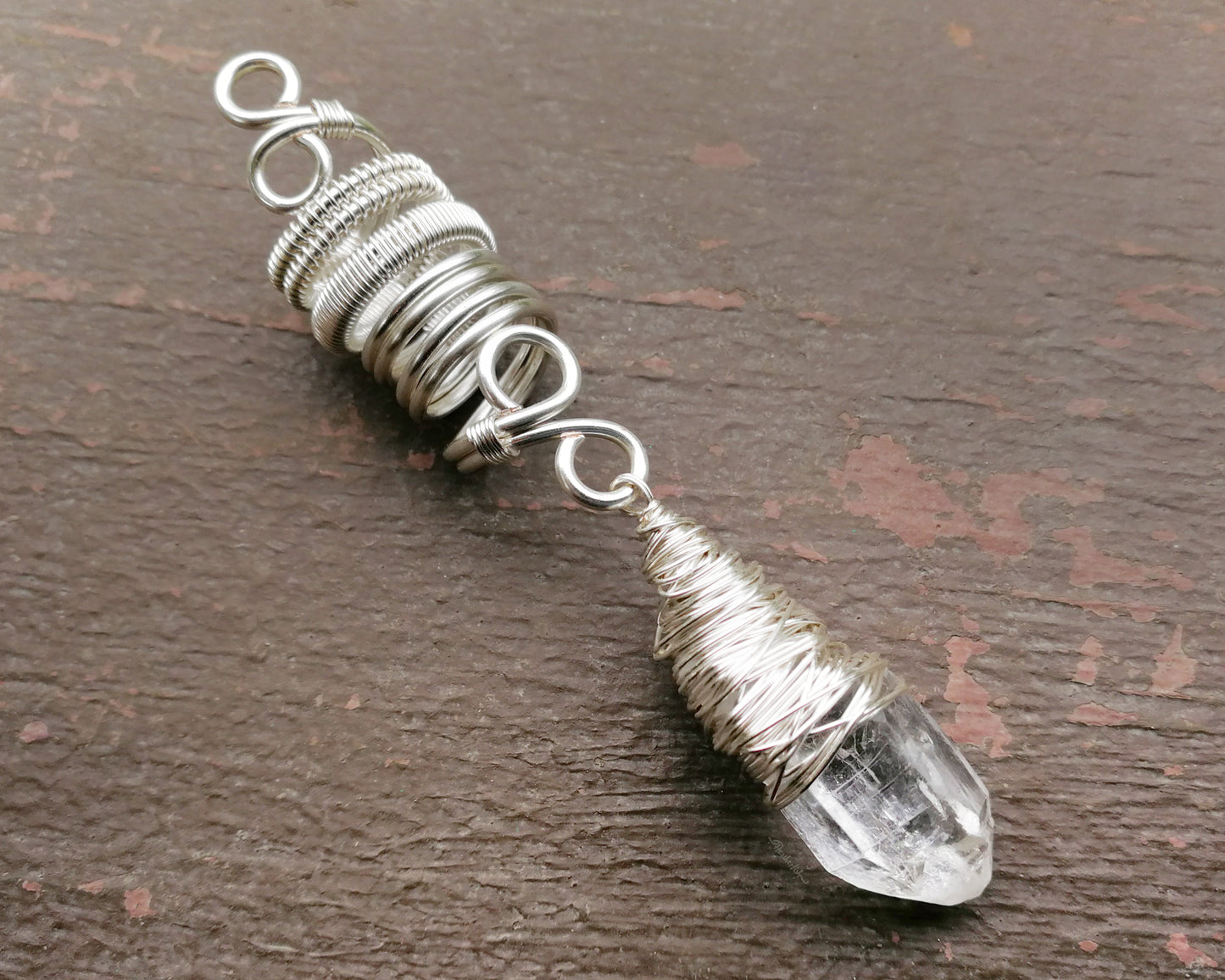 Woven Silver Dread Bead featuring and arkansas quartz crystal on a painted wood background.