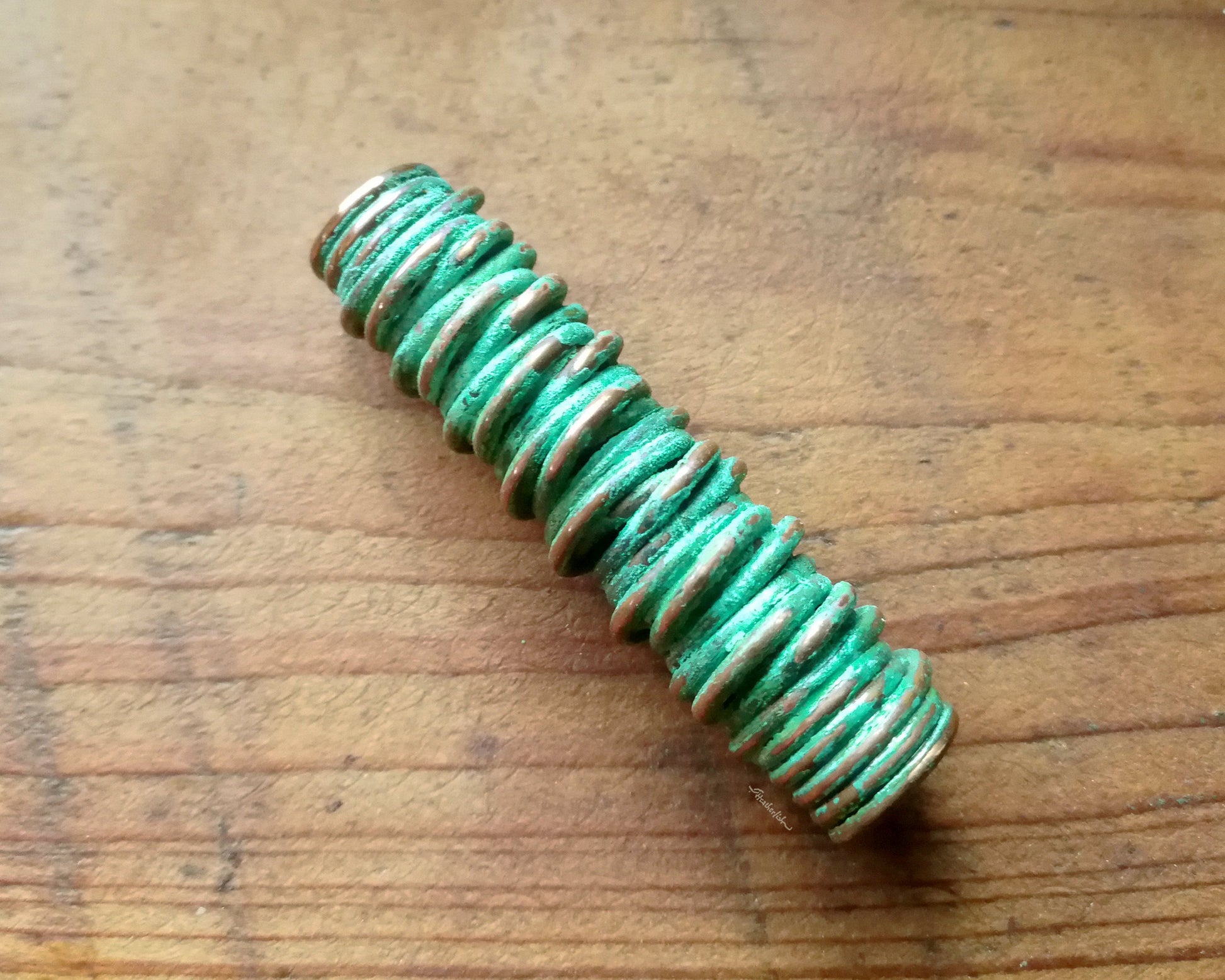 A top view of a Green Patina Copper Dread Bead.